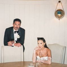 a man and woman sitting at a table with wine glasses in front of their faces