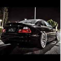 a black car is parked on the street at night