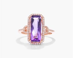 This gorgeous cocktail ring is crafted in 14K rose gold and features a 15.0x6.0mm emerald-cut amethyst center stone. The amethyst is surrounded by a halo of diamonds and the ring band is pav Elegant Amethyst Ring With Rectangular Stone For Formal Occasion, Elegant Formal Amethyst Ring With Rectangular Stone, Diamond Settings, Engagement Ring Styles, February Birth Stone, Dream Ring, Designer Engagement Rings, Diamond Heart, Cocktail Rings