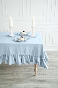 a table with two candles and plates on it