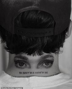 a woman with tattoos on her neck and eyes is looking at the camera while wearing a hat