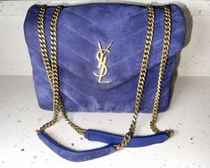 Description & Condition: 100% Authentic YSL Blue Small Suede Loulou Bag This chic bag is crafted of blue quilted suede calf-skin leather exterior in a chevron pattern, and brass hardware and straps. The envelope-style flap has a magnetic closure and opens to blue grosgrain leather lining with two spacious compartments separated by a zipper pocket. This gorgeous bag is perfect for daily use or a special occasion! Size: 9” wide; 6.5” high; 3.5” deep; 12-22” strap drop, able to be worn on the shoulder or crossbody. Included: no items Date code: GAS494699-0820 - Made in Italy in 2020. This has been professionally authenticated by Dr. Runway. VERY GOOD preloved condition. The exterior suede is in good condition with gentle wear and marks. The hardware is in excellent condition. The interior lin Blue Saint Laurent Bag, Ysl Saint Laurent, Blue Chevron, Chic Bags, Gorgeous Bags, Chevron Pattern, Brass Hardware, Magnetic Closure, Zipper Pocket