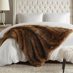 a bed with a fur blanket on top of it