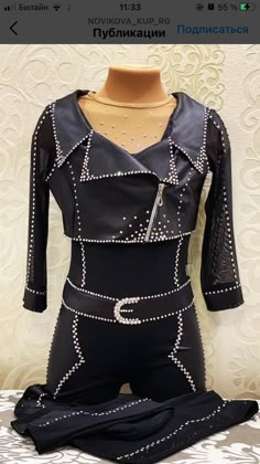 a mannequin is dressed in black with silver studded details on the body