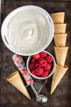 ice cream with raspberries and cones on a tray