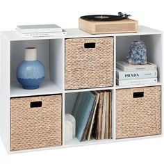 a white shelf with four baskets and a record player