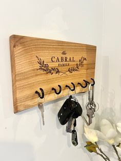 a wooden key holder with keys hanging from it's sides and the name caral family written on it