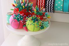 there is a cake decorated with fruit and candy on the top of a white plate