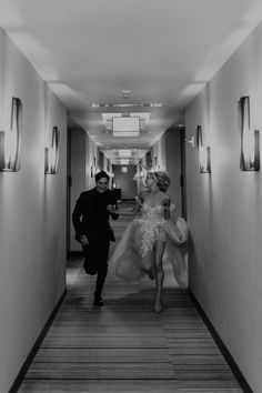 a man walking down a hallway next to a woman