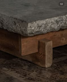 a close up of a stone top on a wooden bench with wood legs and feet