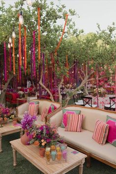 an outdoor seating area with couches, tables and flowers in vases on the table