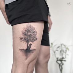 a man with a tree tattoo on his thigh