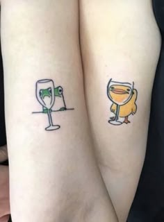 two people with tattoos on their arms holding wine glasses