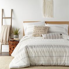 a bed with white sheets and pillows on top of it