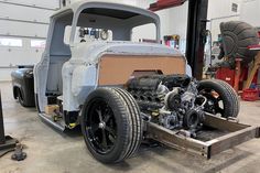 an old truck is being worked on in a garage