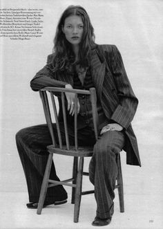 a woman sitting on top of a wooden chair