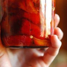 a person holding a jar full of pickles