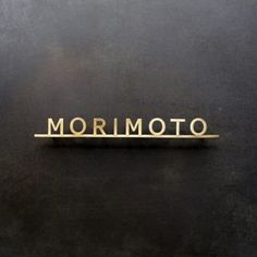 the word mormoto written in gold on a black surface