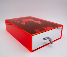 a red and white box sitting on top of a white table next to a pair of scissors