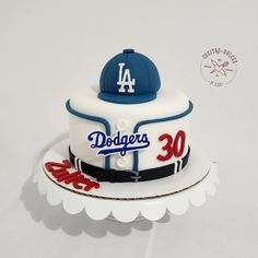 a birthday cake with the number 30 on it and a dodgers baseball cap on top