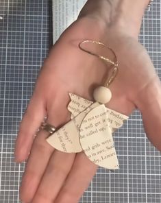 a person's hand holding a piece of paper with an ornament on it