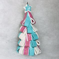 a ceramic christmas tree ornament with gloves on it's sides and a star hanging from the top