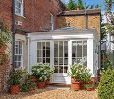 a white house with potted plants and windows