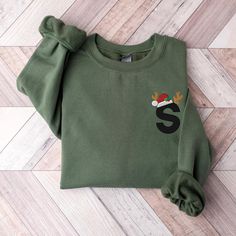 a green sweatshirt with the letter s on it and a santa hat embroidered on the front