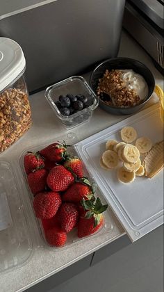 fruit, cereal and yogurt are sitting on the counter