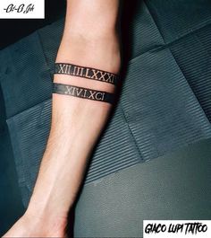 a man's wrist with roman numerals on it and an arrow in the middle