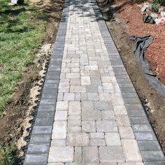 a brick walkway in the middle of a garden