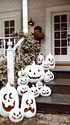 pumpkins with faces carved into them sitting on the steps in front of a house