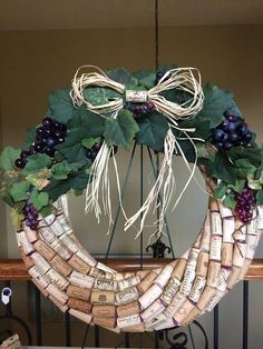 a wreath made out of wine corks with grapes and leaves hanging from the front