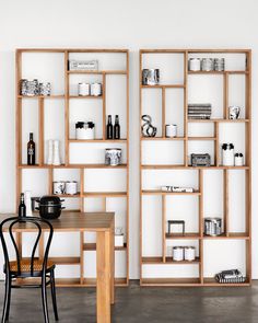 two wooden shelves filled with different types of items on top of each other in front of a white wall