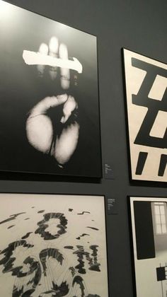 four black and white paintings hanging on the wall