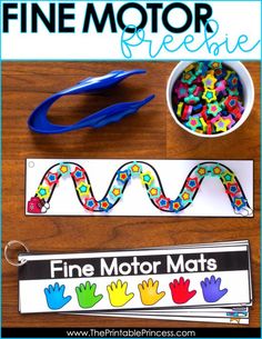 the fine motor mat is next to a cup of beads and scissors on a wooden table