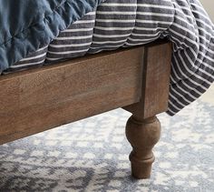 a wooden bed frame with blue and white pillows