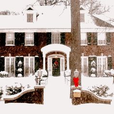 a large brick house covered in snow next to a tree