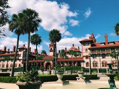 a large building with palm trees in front of it