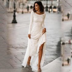 a woman in a white dress is standing on the sidewalk