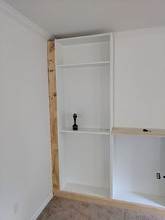 an empty room with white shelving in the corner