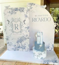 a blue and white cake sitting on top of a table next to a card board