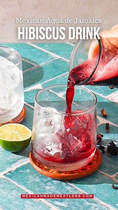 someone pours red liquid into a glass with ice and lime slices on the side