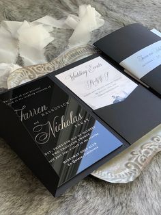 two black and white wedding cards on a furnishing