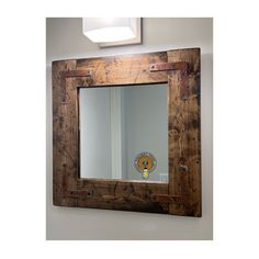 a wooden mirror hanging on the wall