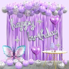 a purple and silver birthday party backdrop with balloons, streamers, and butterflies on it