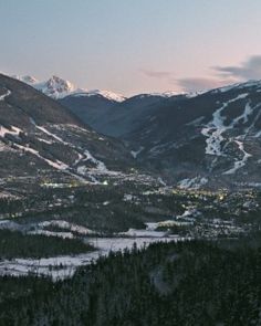 the mountains are covered in snow and lit up by lights at night, as seen from above