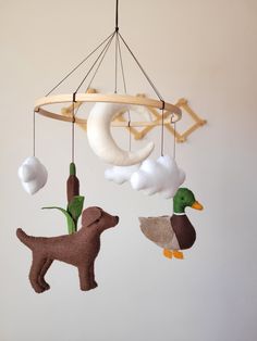 a mobile made to look like a dog, duck and moon hanging from the ceiling