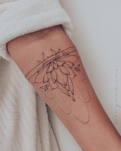 a woman's arm with a tattoo on it and a flower in the middle