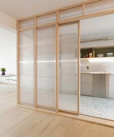 an empty room with sliding glass doors leading into the kitchen